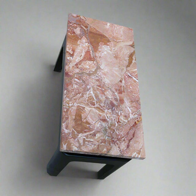 A small low side table attributed to Eleanor Le Maire. Marble top with an ebonized wood base.