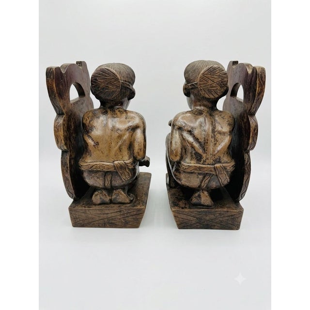 An exceptional and highly detailed pair of mid-century hand-carved ethnographic bookends depicting indigenous musicians...
