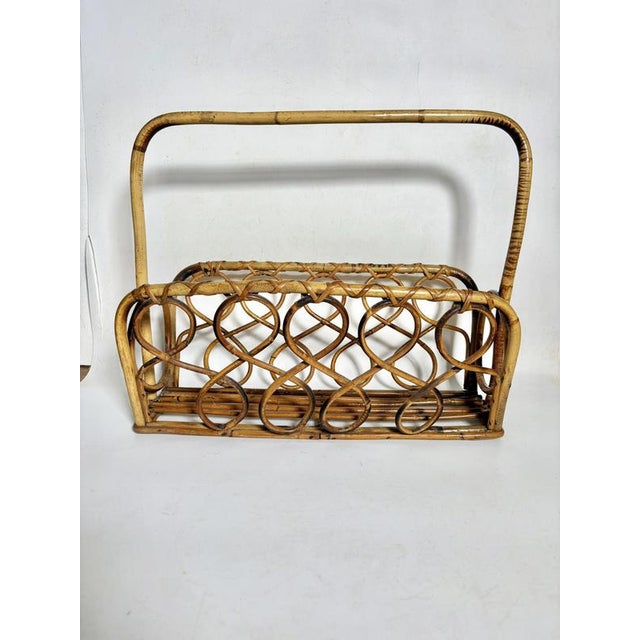 A French magazine rack from the 1960s, crafted from bent rush and rattan, boasting a light and harmonious structure. The...