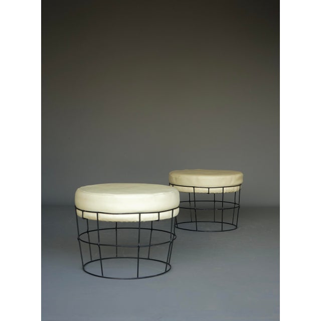 A pair of stylish midcentury hocker stools in the style of Verner Panton or Harry Bertoia. They have original faux-leather...