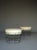 A pair of stylish midcentury hocker stools in the style of Verner Panton or Harry Bertoia. They have original faux-leather...