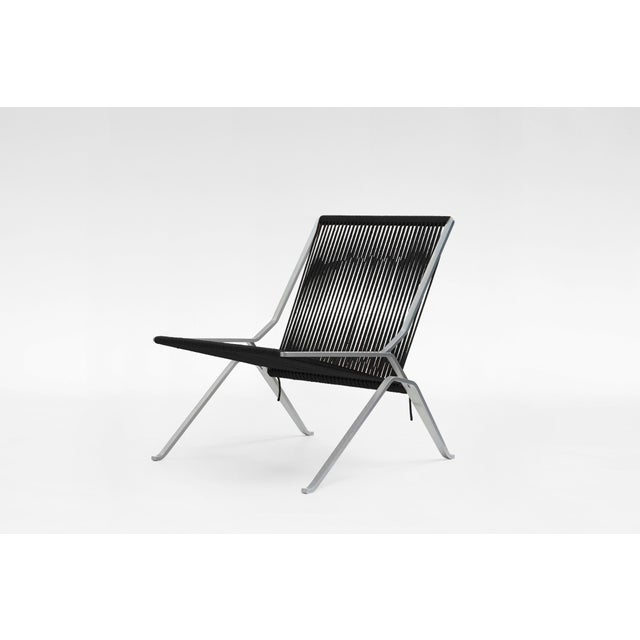 PK25 lounge chair designed by Poul Kjærholm and manufactured by Fritz Hansen. Featuring a black flagline seat and a...