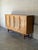 This striking sideboard features four doors and four base drawers for expansive storage. The facade highlights geometric...