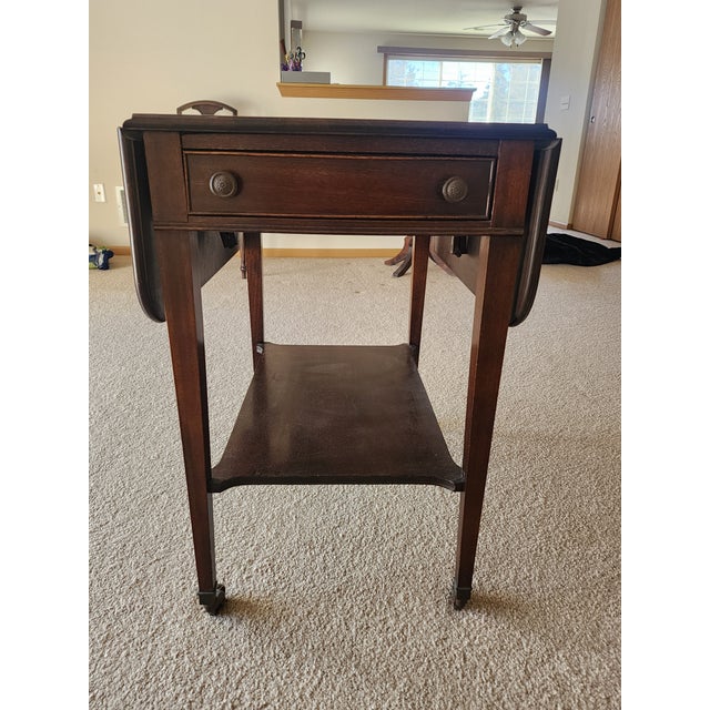 Brandt 4902 drop-leaf cart table. Vintage 1940s mahogany. It is on casters. One drawer that opens. The other side just...