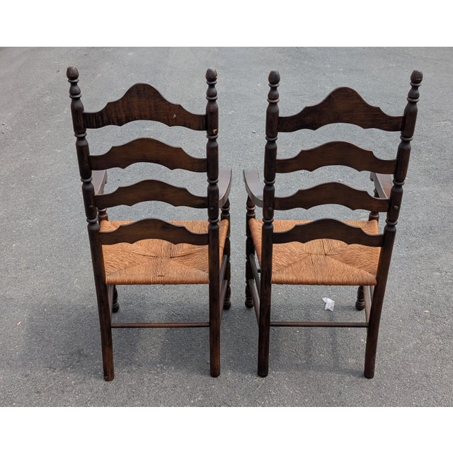 Elevate your dining space with this striking pair of 1960s American Colonial Revival armchairs, a masterful blend of mid-...