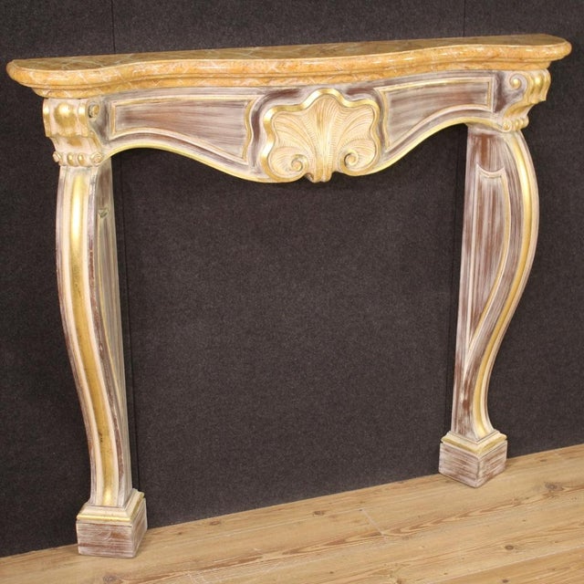 Italian fireplace from the second half of the 20th century. Front fireplace decoration in carved, lacquered and gilded...