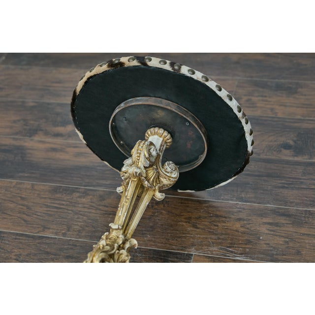 An Italian Baroque Revival period accent table from the 19th century with carved gilded base and zebra top. This...