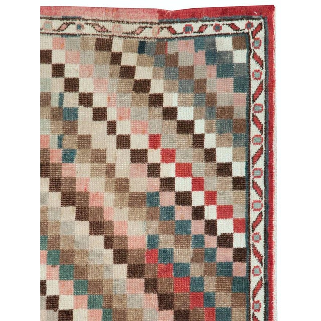 This mid-20th-century Turkish Anatolian square carpet presents a lively checkerboard field arranged in sweeping diagonal...