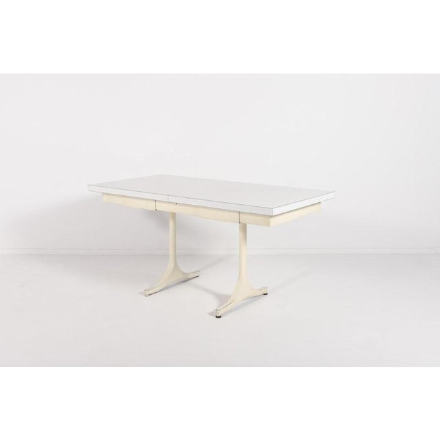 The table has a white laminate top and features white painted steel legs. The table is wonderful as a dining table or as a...
