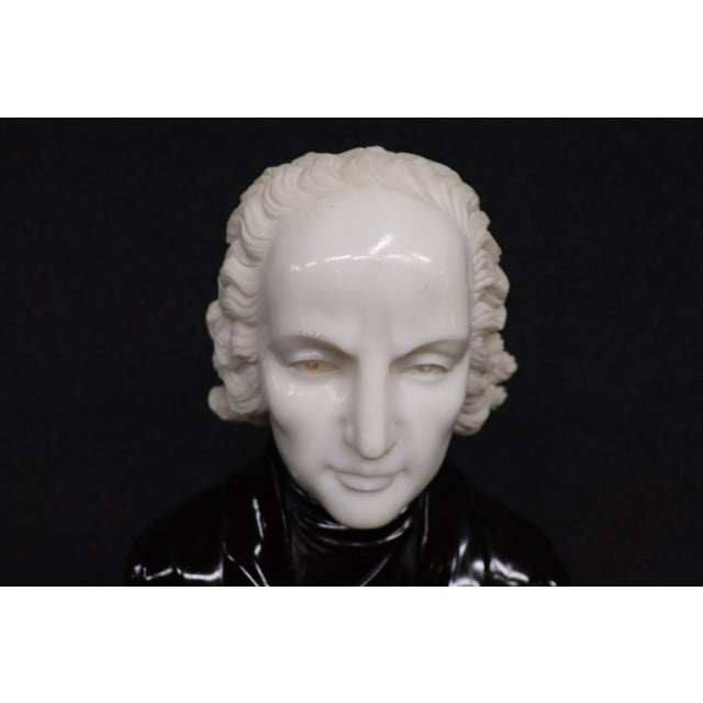 Sculptural bust of Wolfgang Amadeus Mozart, crafted in contrasting white, black, and peach-toned marble. The portrait...