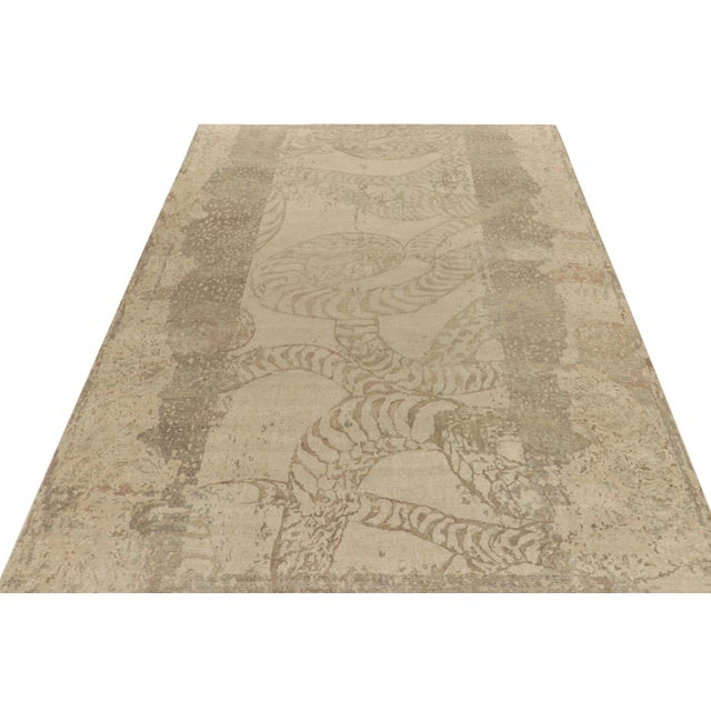 From Rug & Kilim’s Homage collection, a 10x14 distressed style abstract rug relishing a forgiving play of beige-brown and...