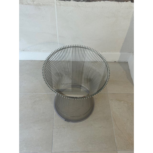 Side table made of thin steel rods intertwined to form a curved column. Removable glass top. This piece has an attribution...