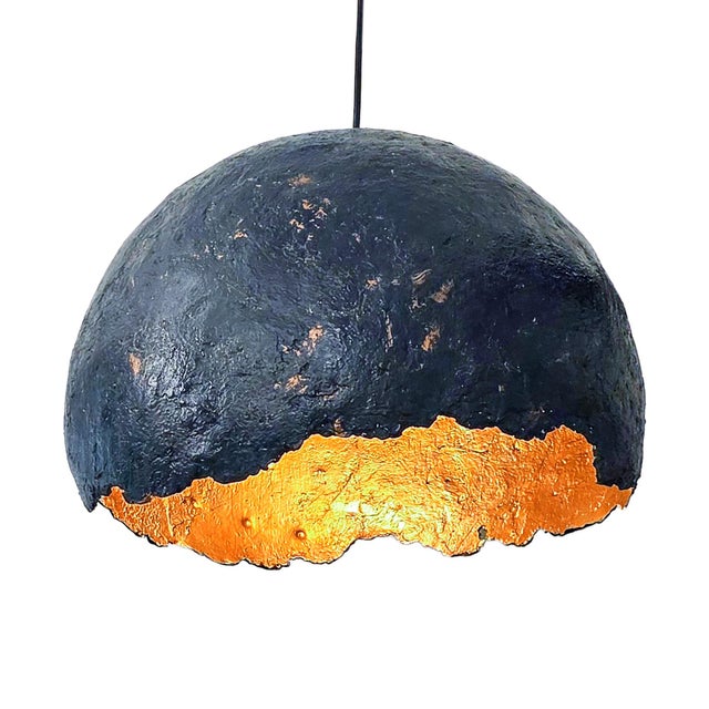 This pendant lamp from the "Cupola" series is a unique piece that blends the simplicity of paper with the preciousness of...