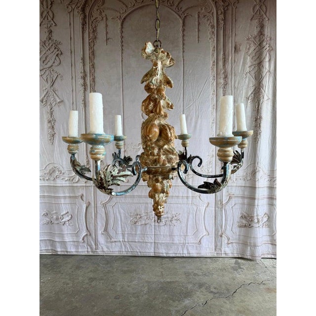 Exceptional early 19th-century in the style Italian Rococo chandelier, carved wood with wrought iron arms. This statement...
