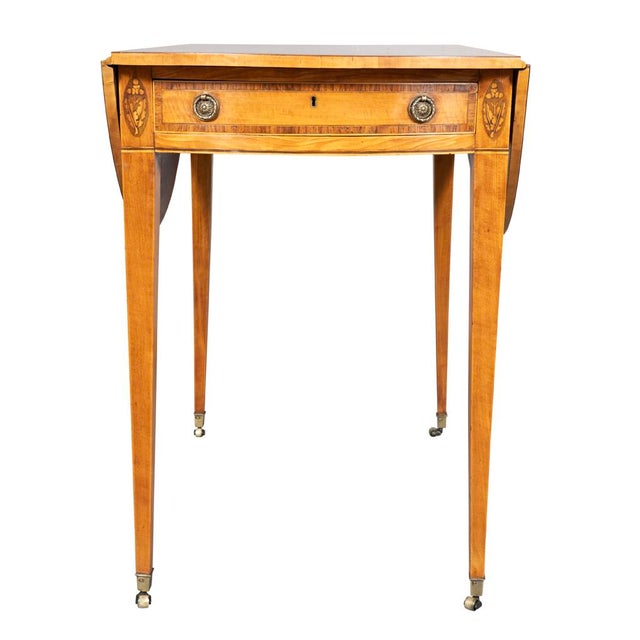 Rectangular with D shaped leaves. The frieze with a drawer flanked by oval oak leaf inlay. Square tapered legs with casters.