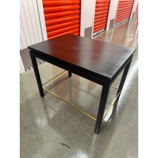 Dunbar side table in dark finish with brass stretcher detail