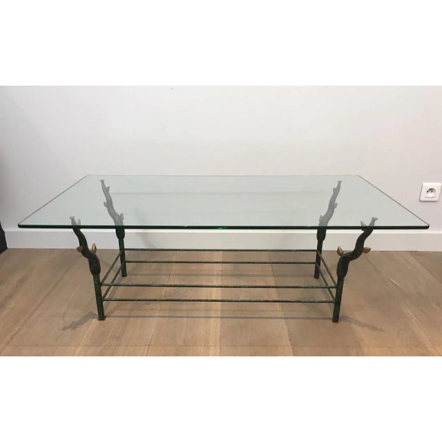 In the style of Garouste et Bonetti. Unusual wrought iron coffee table with a black lacquered base with gold tree branches...