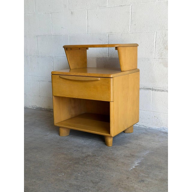 This vintage bedside chest features a distinctive step-table design with an integrated upper shelf over an open storage...