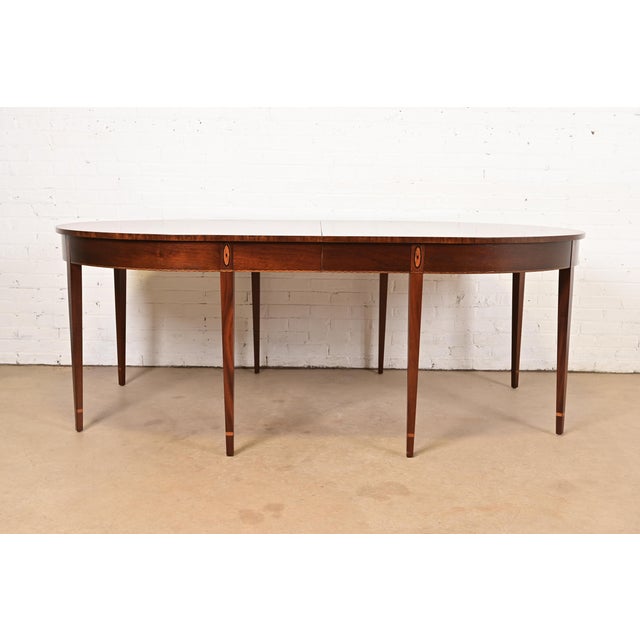 A beautiful Federal or Hepplewhite style dining table In the manner of Baker Furniture USA, Circa 1980s Gorgeous book-...
