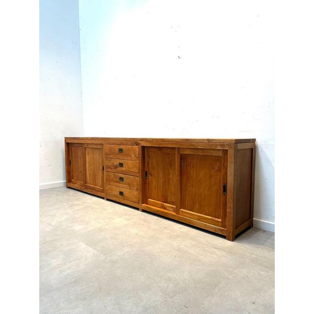 Impressive extra-long teak sideboard featuring a clean, architectural design and a beautiful warm wood grain. Crafted from...