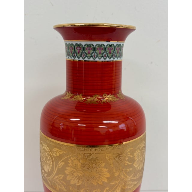 Japanese porcelain vase by Shibata featuring a deep red ground with gold floral decoration and patterned border details....