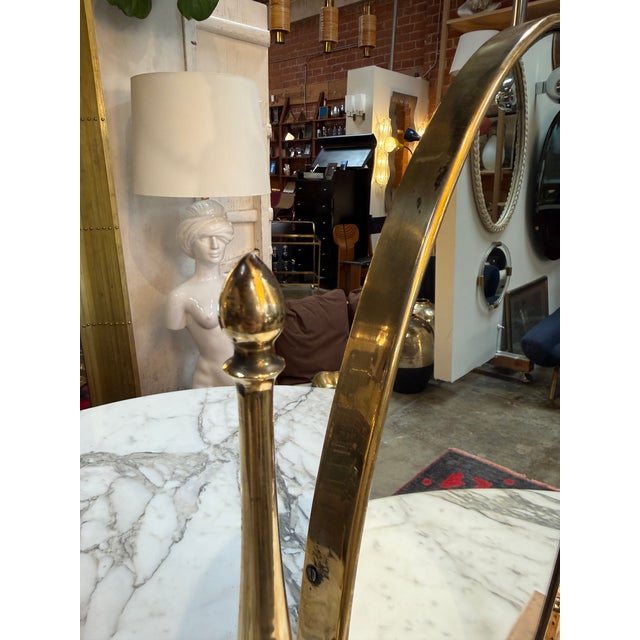 Elegant vintage tabletop vanity mirror featuring a classic oval shape set within a polished brass frame. The mirror is...