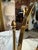Elegant vintage tabletop vanity mirror featuring a classic oval shape set within a polished brass frame. The mirror is...
