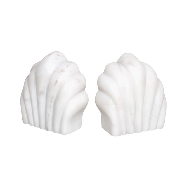 A pair of scallop shell shaped bookends. White Italian Carrara marble with subtle veining is carved into two scallop shell...
