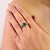 This elegant ring crafted in 925 sterling silver features a striking oval emerald at the center, beautifully accented with...