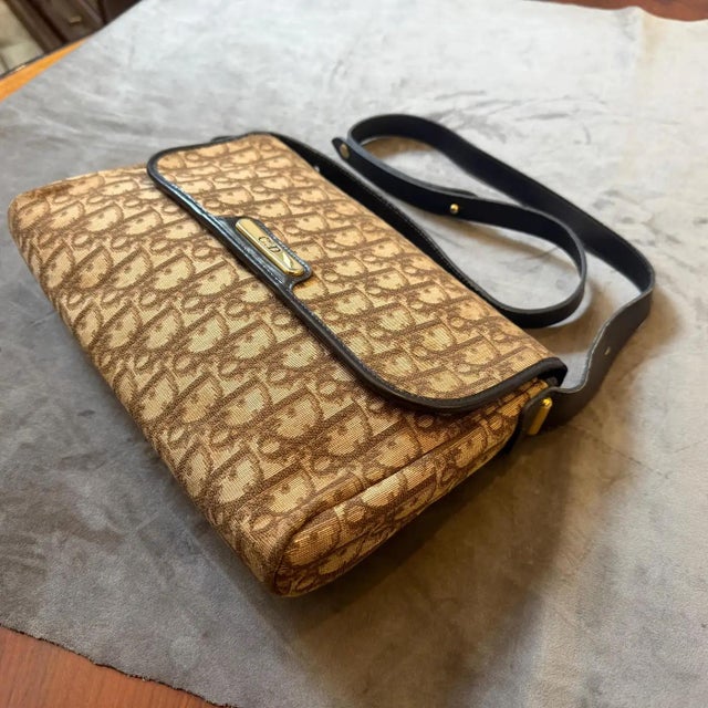 This vintage Christian Dior Trotter Canvas shoulder bag is a rare find from the 1980s, featuring the iconic brown and...