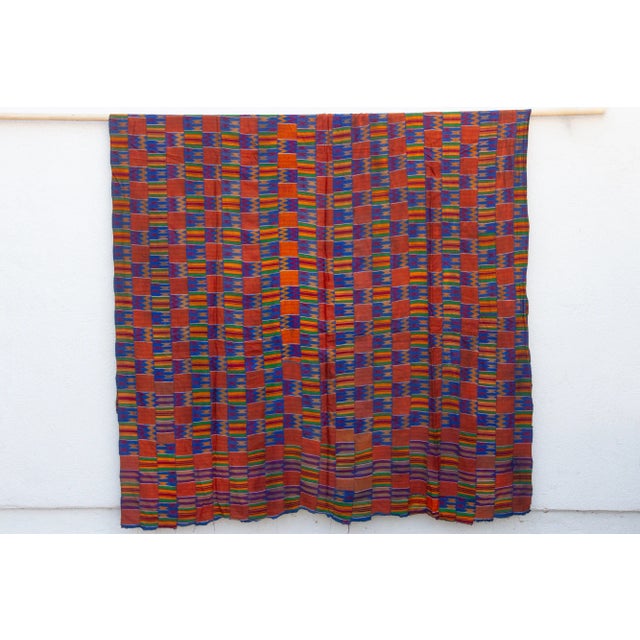This extraordinary Asante Kente cloth is a true masterpiece of textile art. Handwoven from luxurious silk, it commands...