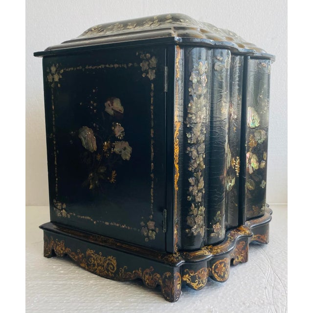Antique English papier mache cabinet with a writing slope. The top lid opens to a series of divided spaces for small...