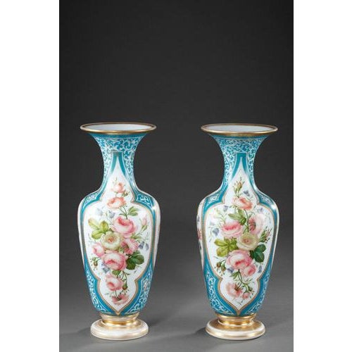 An enamel opaline baluster-shaped pair of vases decorated with polychromatic flowers in lobed cartridges on light blue...