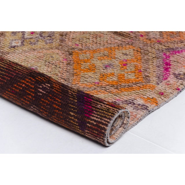 This is a vintage Turkish Oushak rug from the Mid 20th Century. The piece was hand-knotted.