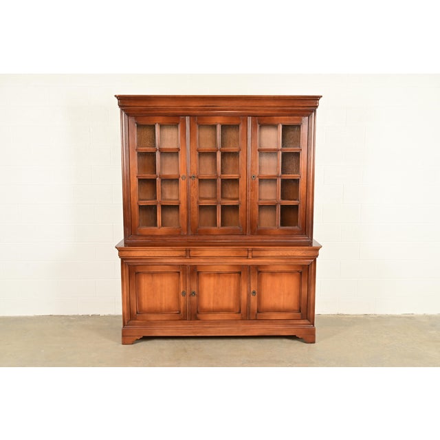 A gorgeous French Louis Philippe style two-piece breakfront bookcase cabinet Attributed to Grange France, Circa 1960s...