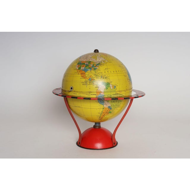 Yellow tin litho world globe produced by Replogle as part of its "Globe-Grams" series of instructional games for children...