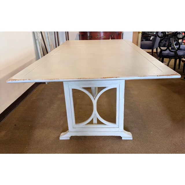 This generous rectangular dining table is finished in a beautifully distressed antique white, with warm wood tones peeking...