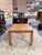 A striking burl wood Parsons dining table showcasing richly figured veneer and a clean, architectural silhouette. And the...