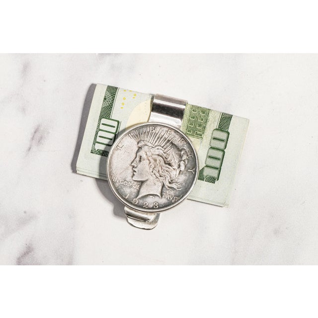 A striking fusion of American numismatic history and mid-century craftsmanship, this vintage sterling silver money clip...
