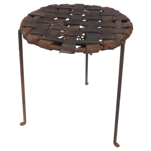 A handsome pair of wrought iron and woven leather stools by Lila Swift & Donald Monell. Beautifully simple, three-legged...