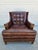 A vintage Hancock & Moore tufted lounge chair with brass tacks along the base and casters under the front legs. This...