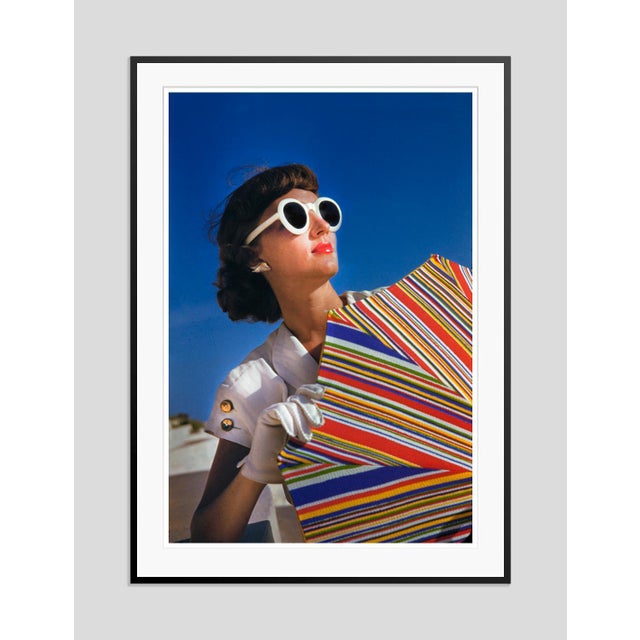 Vogue Sunshine by Toni Frissell A vogue model poses for her shoot on a beach holding a colourful umbrella, 1946. (Toni...