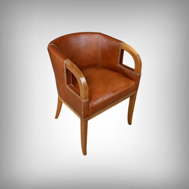A set of four Art Deco armchairs in walnut and leather, made around 1940, displaying an aesthetic that is both...