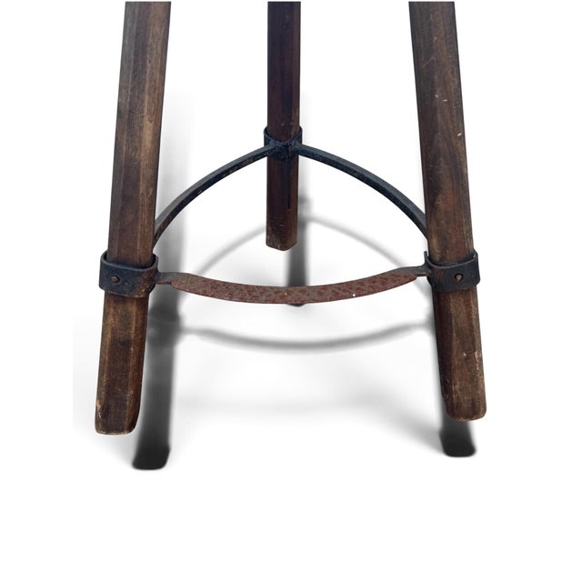 A striking vintage hand-crafted bar-height stool combining sculptural carved wood with hand-worked iron details. The...