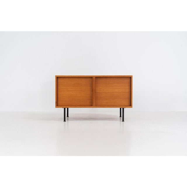 Minimalist cabinet by Gunter Renkel for Rego (Germany, 1960s). Crafted in warm teak, the cabinet features clean...