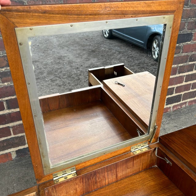 Art deco vanity with collapsible mirror and storage drawers. This piece has an upholstered foot rest underneath.