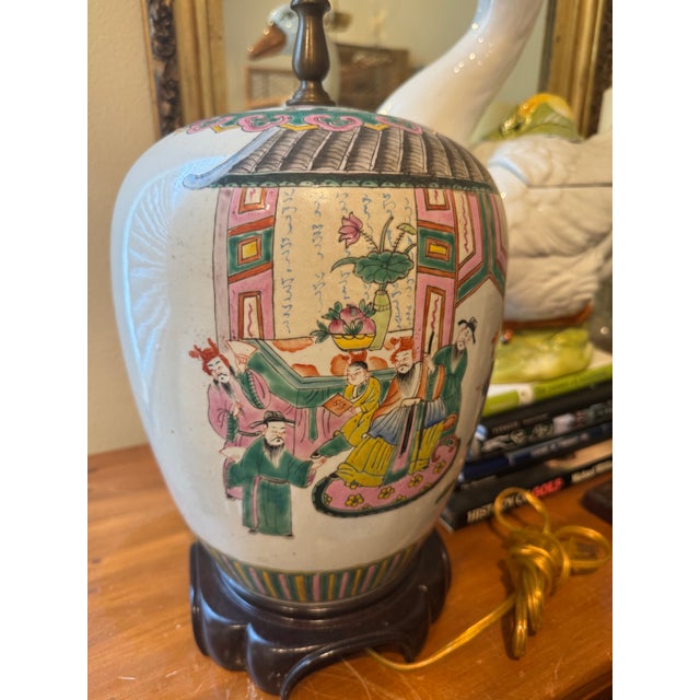 This Chinoiserie lamp is made from a ginger jar with a lid. The porcelain lamp is decorated with traditional Asian figures...
