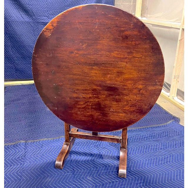 This charming 18th-century Provincial French tilt-top wine tasting table exudes old-world character and rustic elegance....