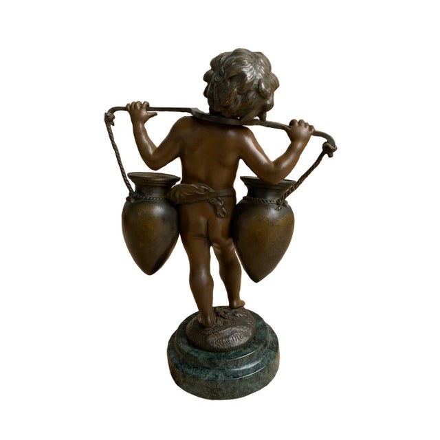 A fine late 19th century bronze sculpture depicting a young boy carrying two jugs over his shoulders. The bronze is signed...