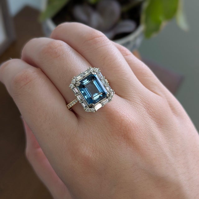 A london blue topaz glows in a deep, steely blue at the centre of this solid 14K white & yellow gold ring, encircled by...